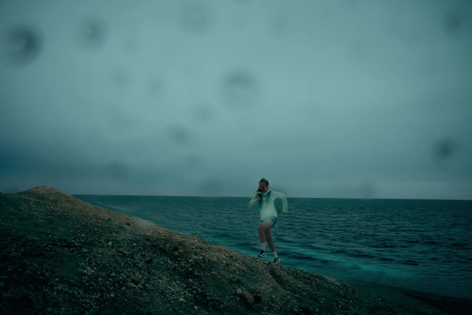 A runner on the rocks above the water